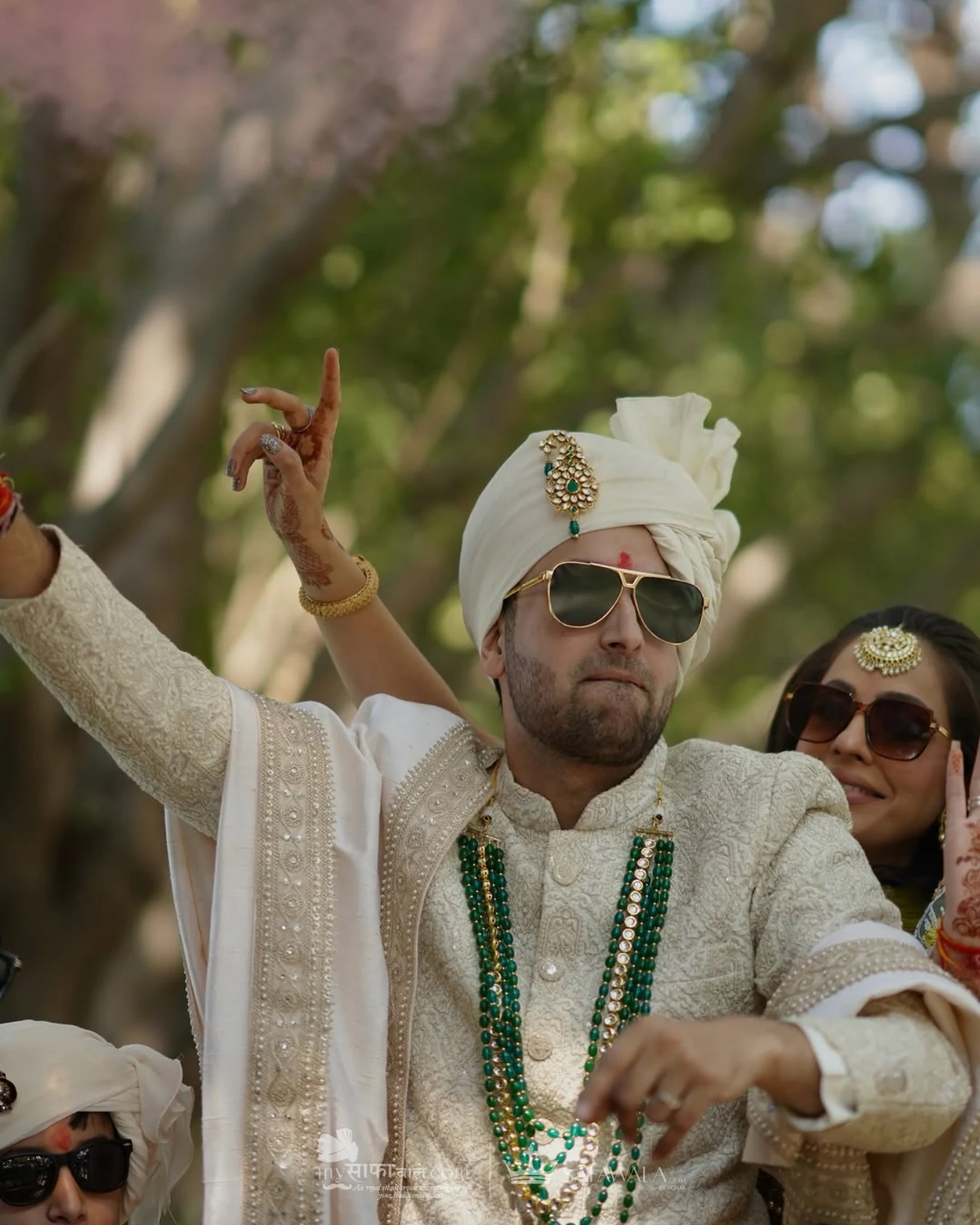 Groom in an ivory wedding safa with emerald jewellery for Raja Park